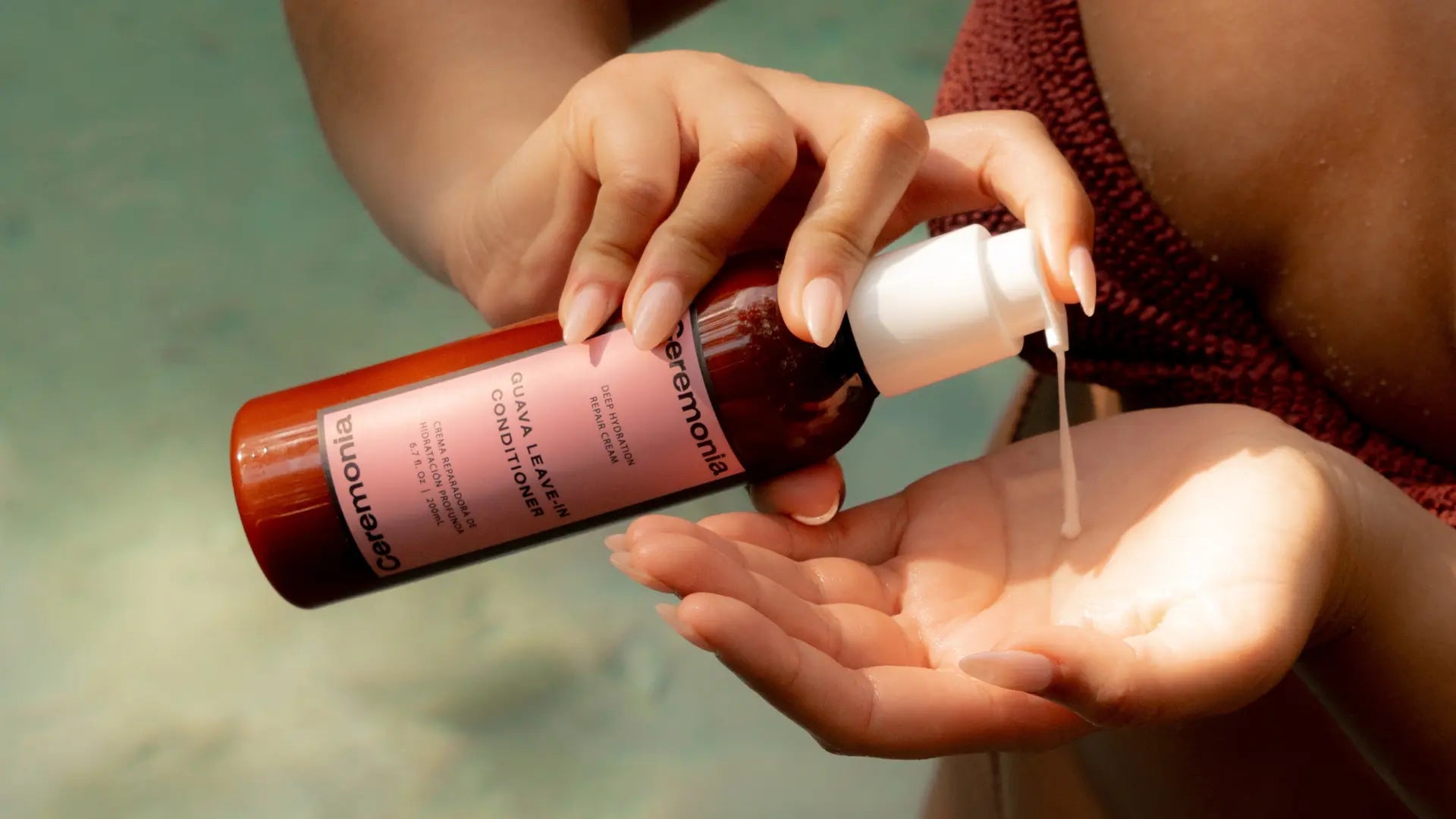Hair products with guava shown in use as woman dispenses Ceremonia Guava Leave-In Conditioner into her hand by the pool.