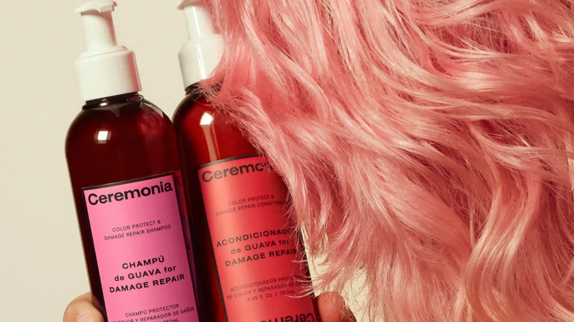 Sulfate-free shampoo and conditioner from Ceremonia held next to soft, pastel pink hair.