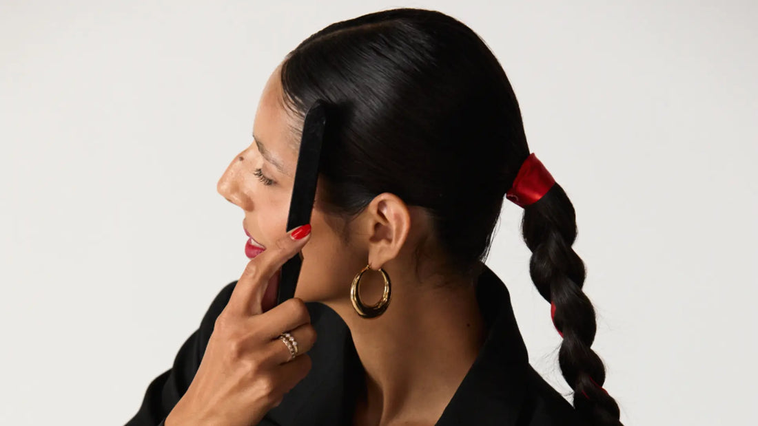 Sulfate-free shampoo keeps hair smooth and shiny, shown on woman styling sleek braided ponytail with red ribbon.