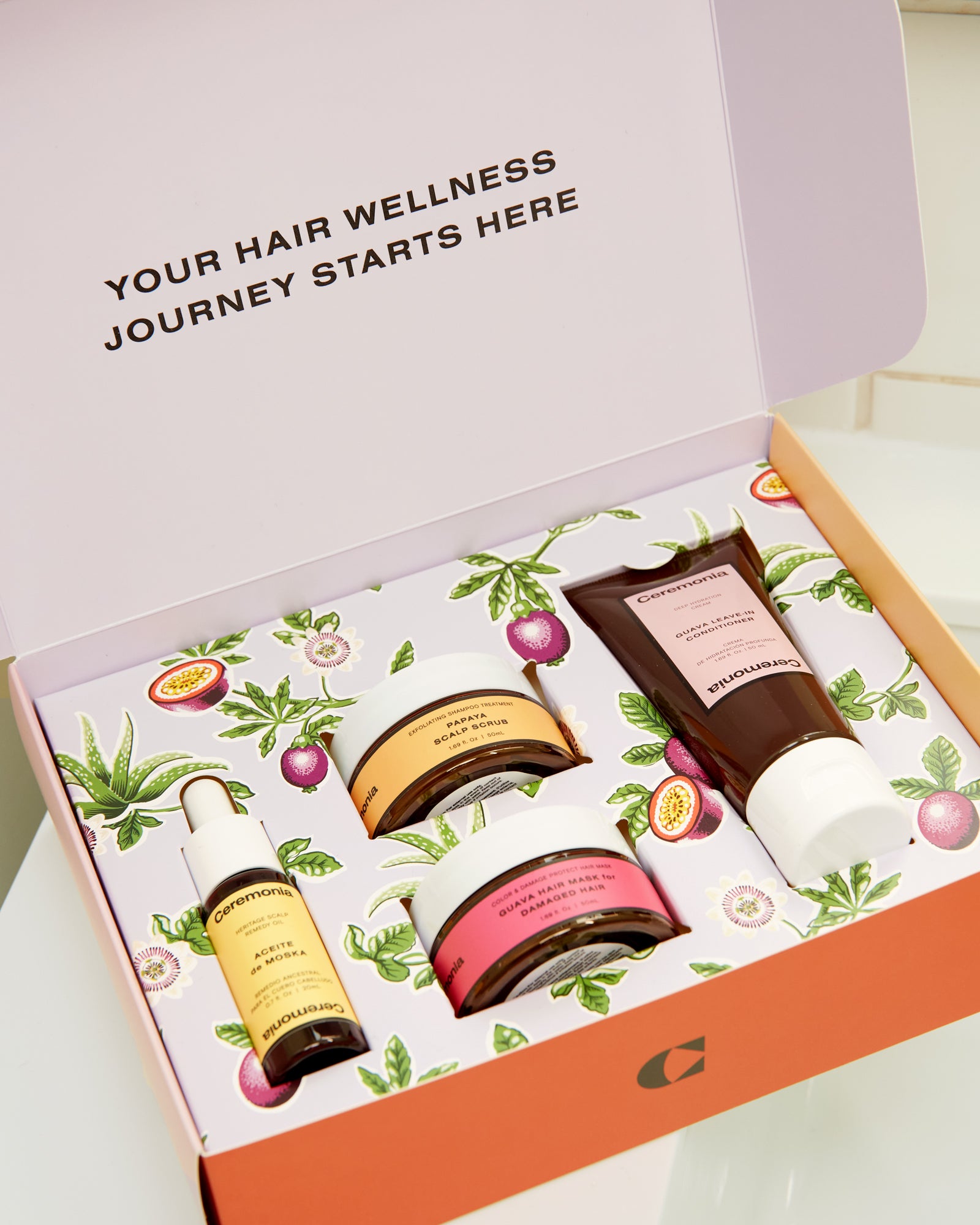 Papaya scalp scrub included in Ceremonia’s Hair Wellness Kit, neatly arranged alongside other hair care products in decorative packaging.