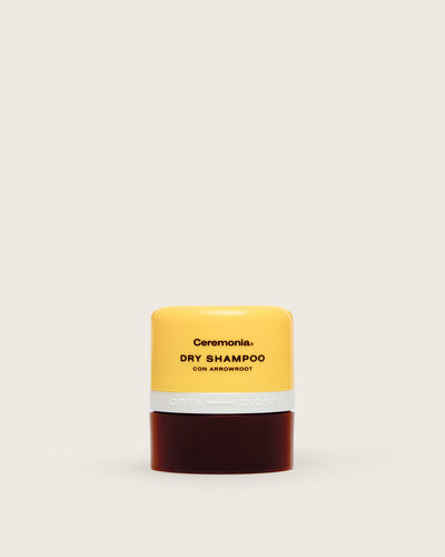 Non aerosol dry shampoo by Ceremonia in a yellow and brown container with twist-open applicator and arrowroot formula.