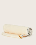 Hair towel in soft beige fabric with Ceremonia branding and wooden button detail, displayed unboxed.