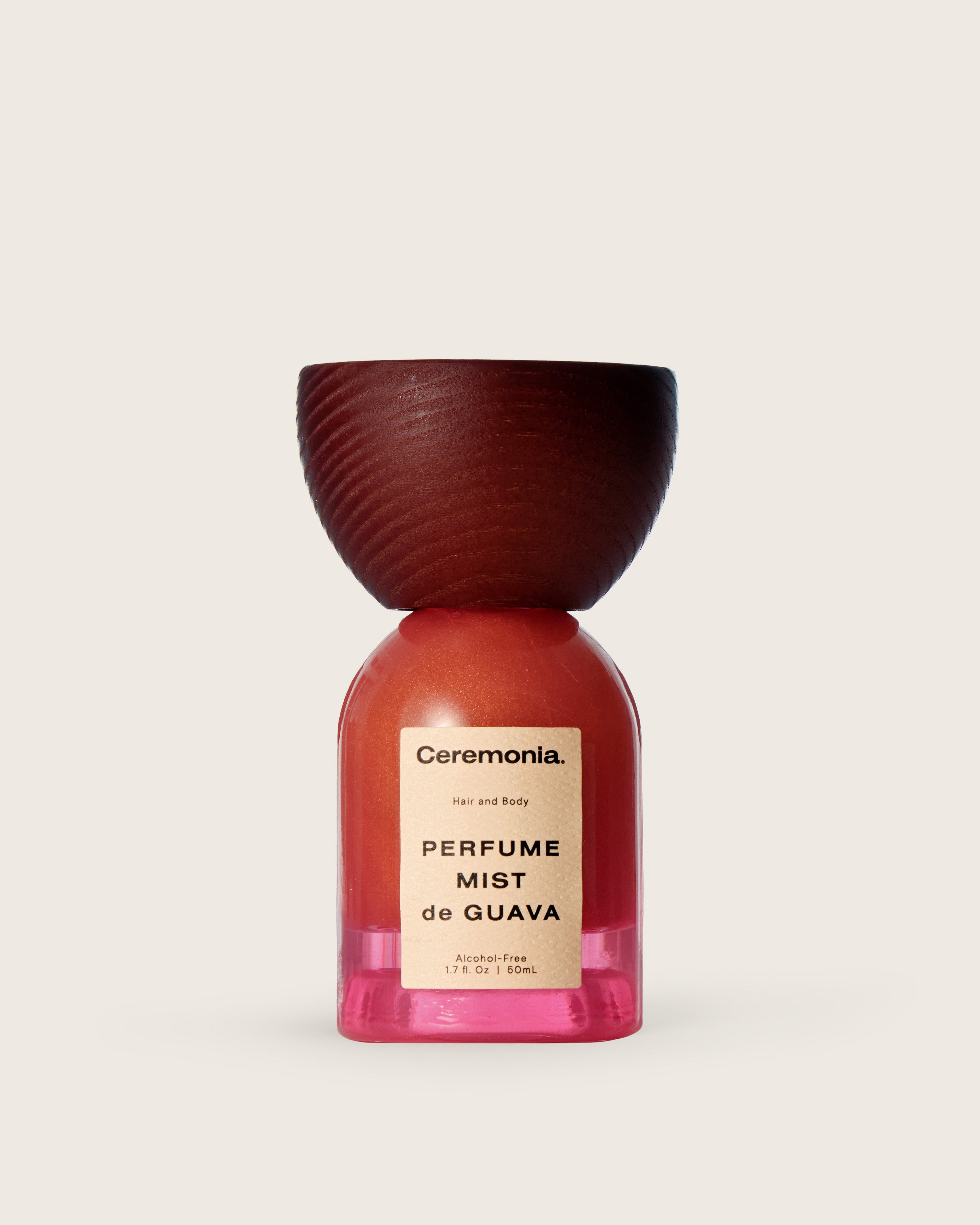 Guava perfume mist for hair and body in a pink bottle with a wooden cap and alcohol-free formula.
