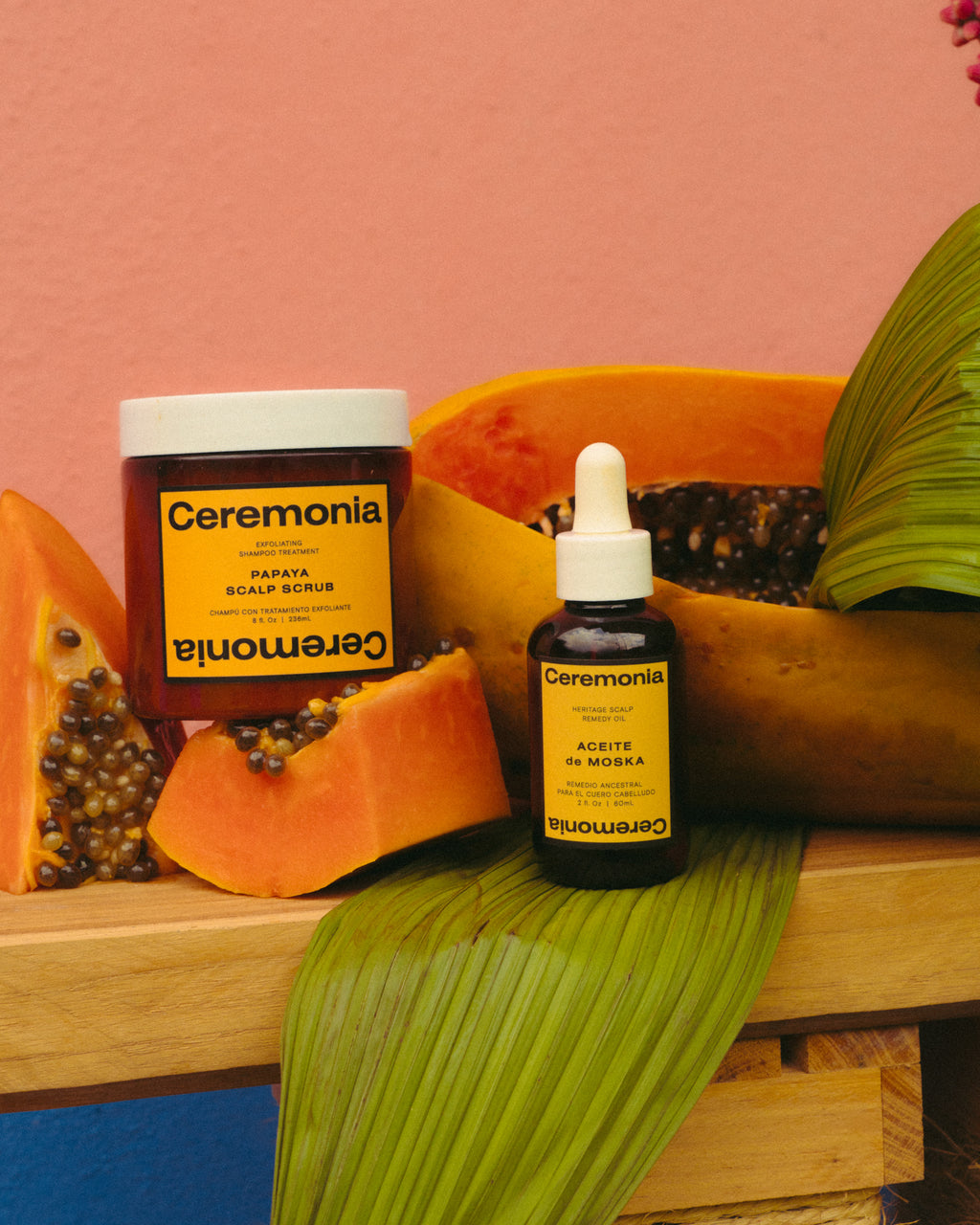 Papaya scalp scrub displayed with tropical papaya slices, featuring Ceremonia's exfoliating shampoo treatment for a refreshed, healthy scalp.