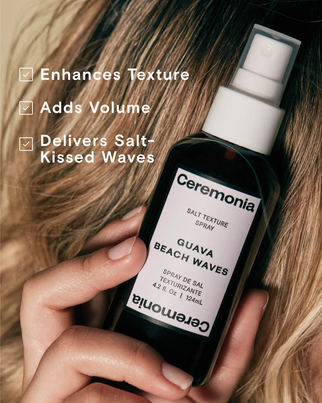 Guava Beach Waves salt texture spray held against tousled blonde hair, enhances texture and adds volume.