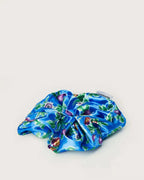 Blue scrunchie with a vibrant passionfruit pattern from Ceremonia displayed against a plain white background.