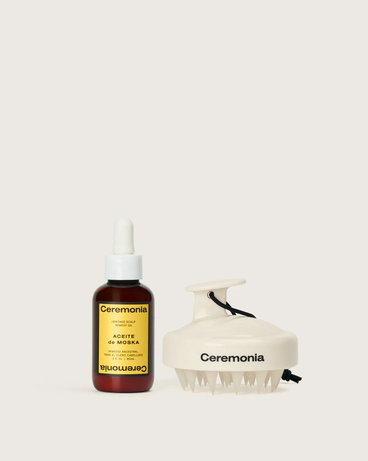 Ceremonia Aceite de Moska scalp oil dropper bottle beside a cream silicone scalp massager.