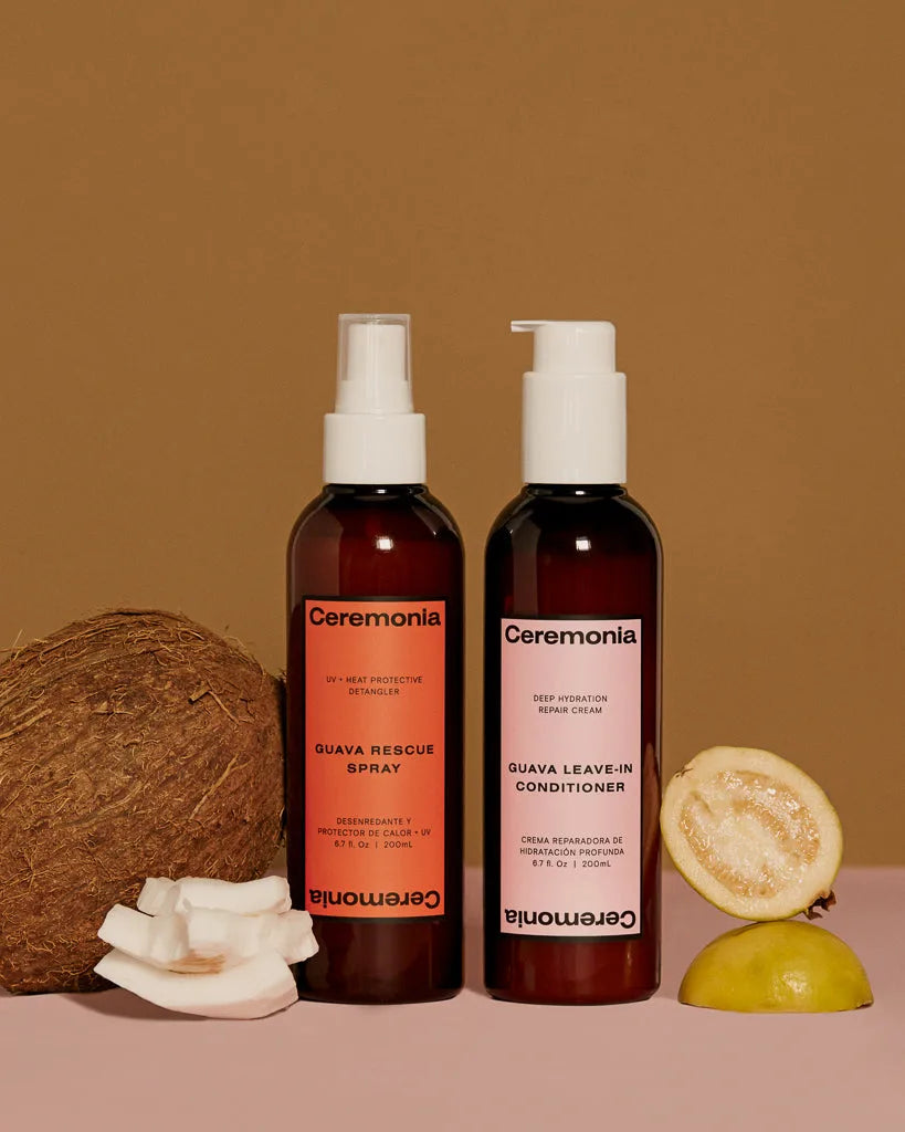 Ceremonia Guava Rescue Spray and Leave-in Conditioner styled with coconut and fresh guava halves.