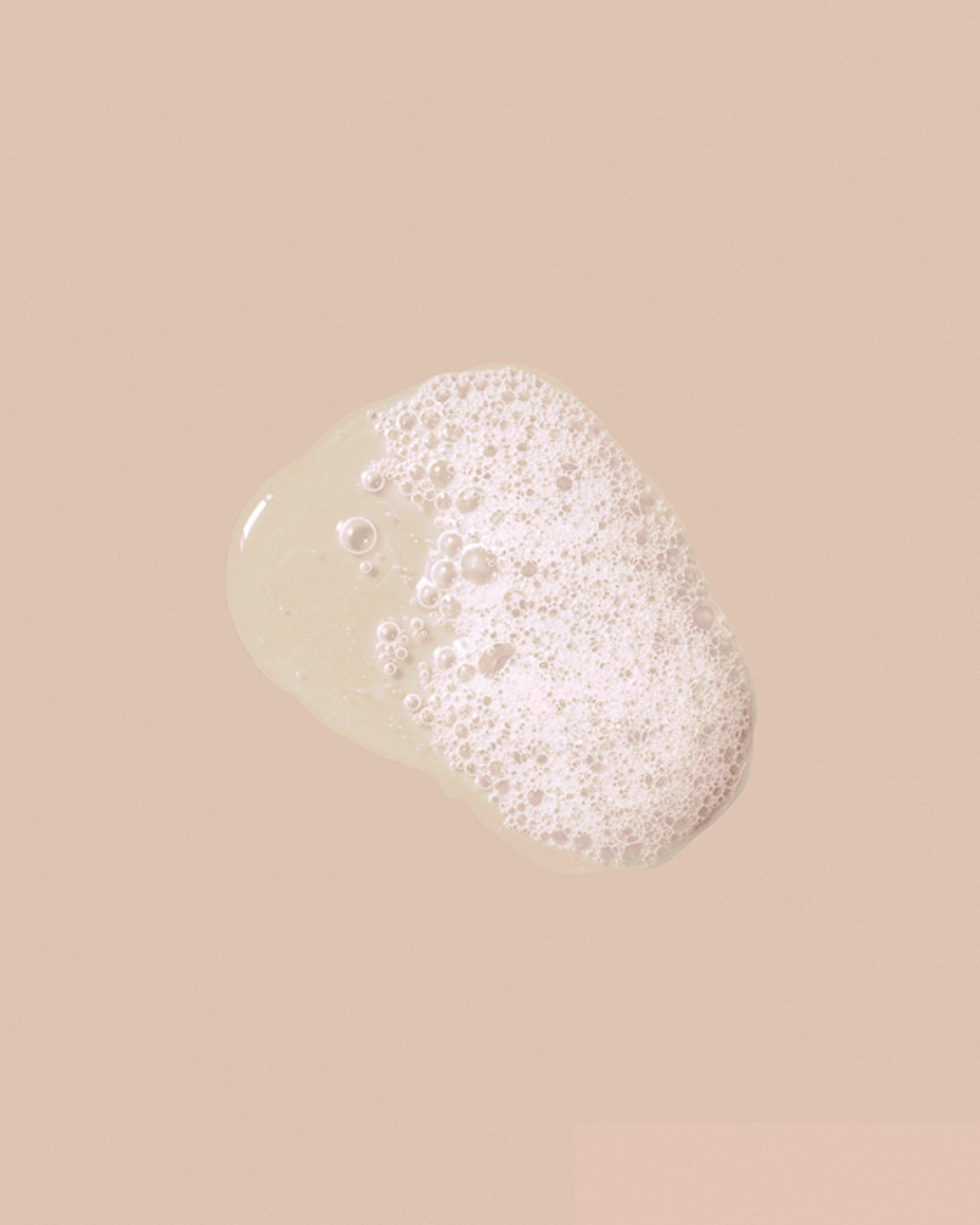 Foamy swatch of Weightless Hydration shampoo lather on a soft blush background.